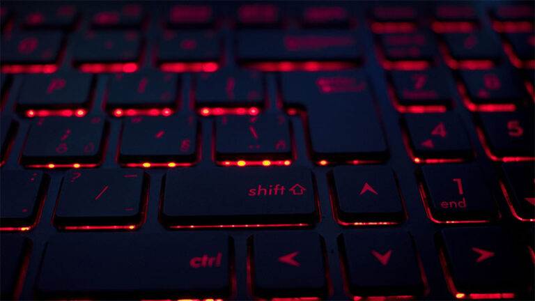 A close-up of a dark keyboard with red backlighting, highlighting keys such as Shift, Ctrl, and arrow keys, reminiscent of a vibrant Miami night in Florida.